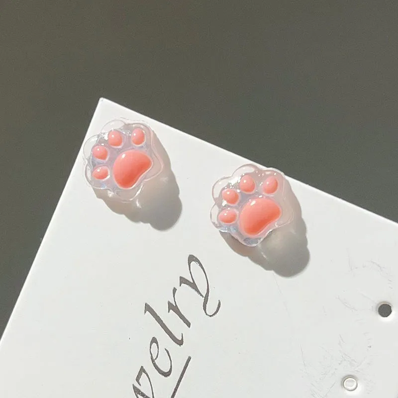 Cat paw magnetic ear clips in transparent pink colour with plastic resin finish, packaged as one pair