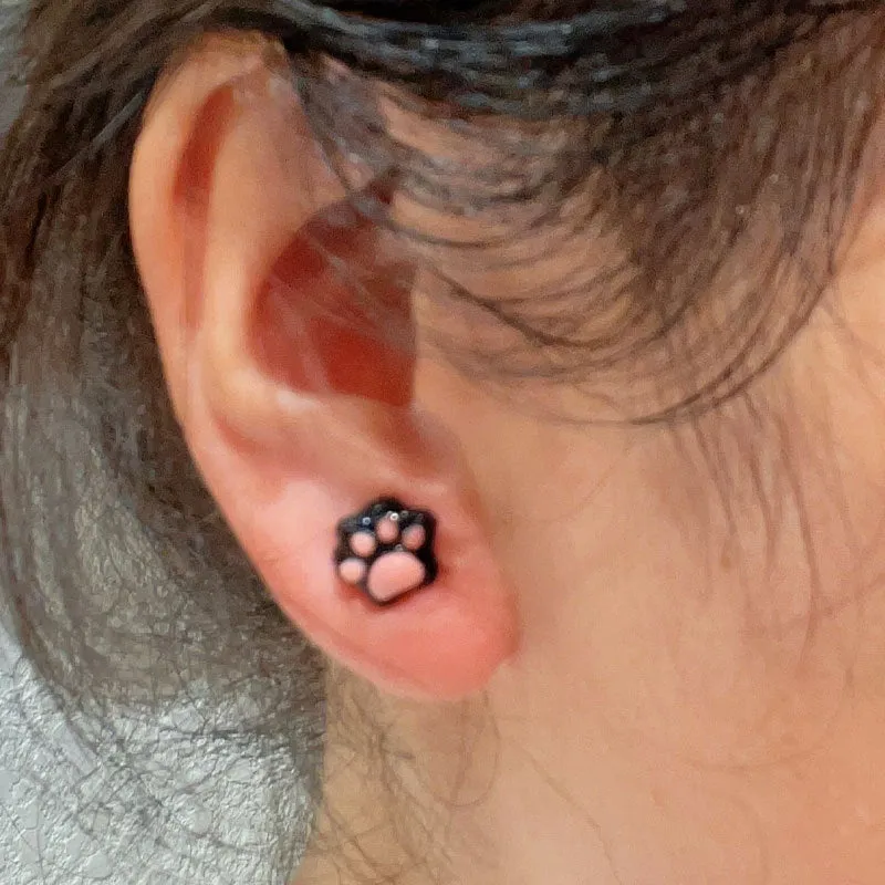 Cat paw magnetic ear clips in transparent pink colour with plastic resin finish, packaged as one pair