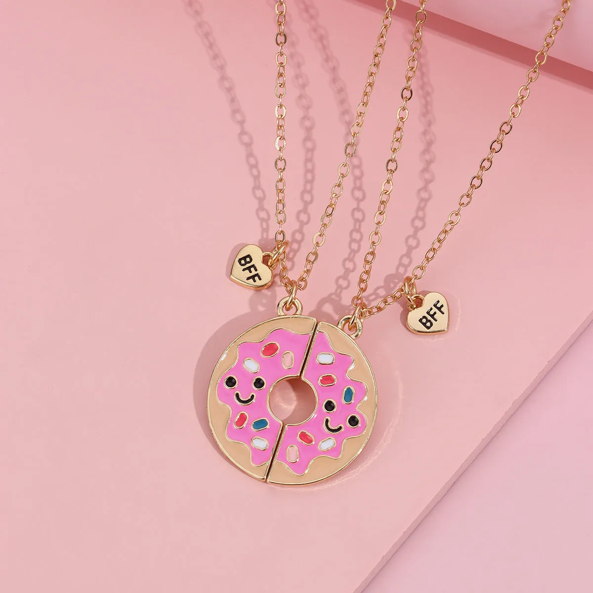 Two matching zinc alloy pendants in donut and watermelon shapes with glossy oil drip finish on cross chains