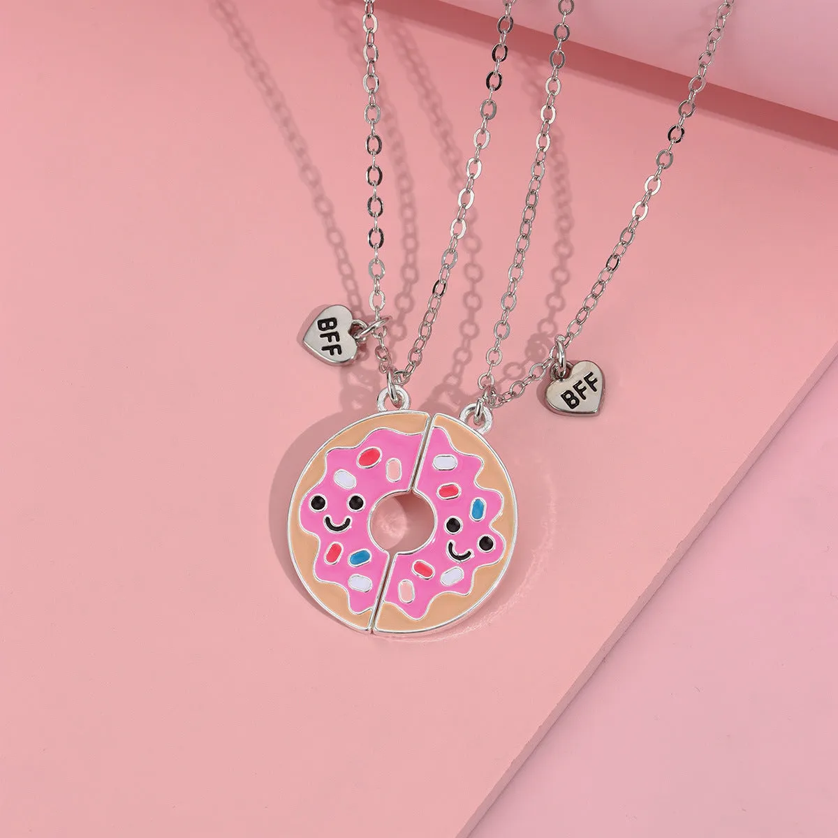Two matching zinc alloy pendants in donut and watermelon shapes with glossy oil drip finish on cross chains