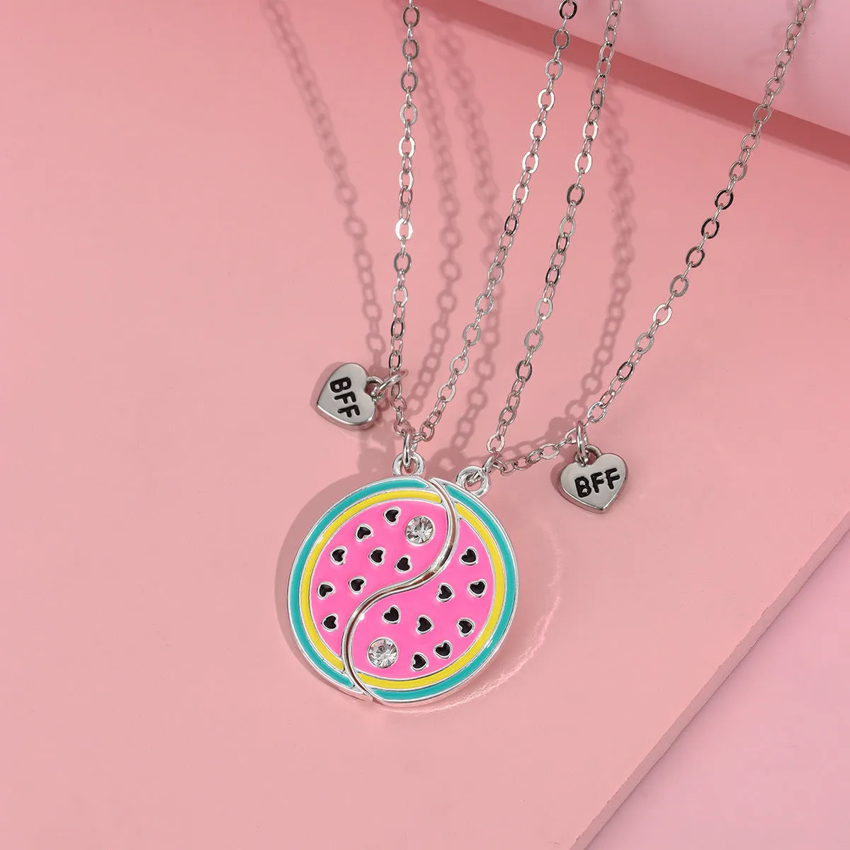 Two matching zinc alloy pendants in donut and watermelon shapes with glossy oil drip finish on cross chains