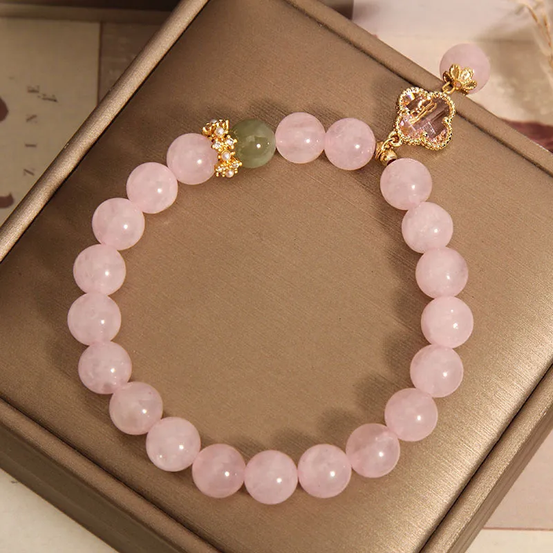 Pink crystal women's bracelet with a four-leaf clover pendant and sparkling rhinestone details.