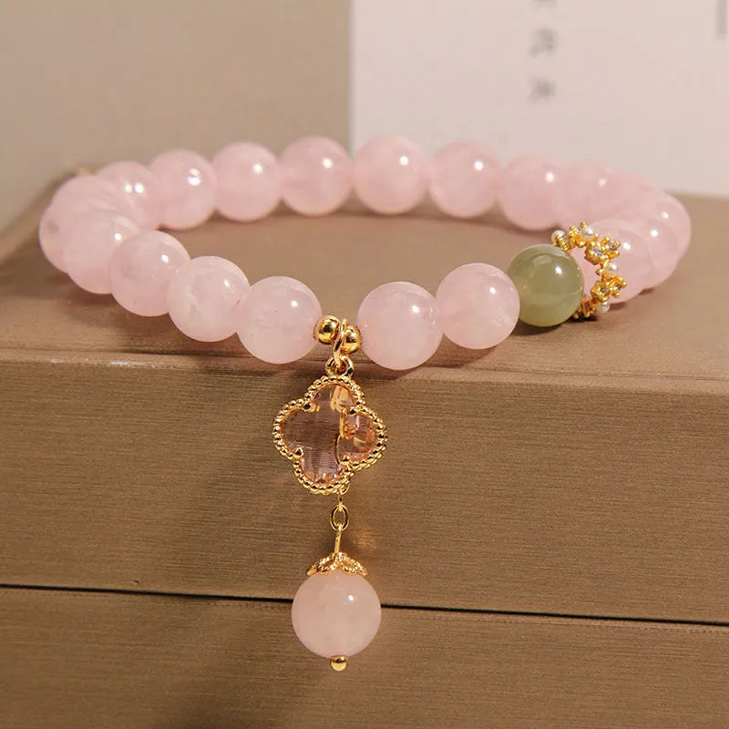 Pink crystal women's bracelet with a four-leaf clover pendant and sparkling rhinestone details.
