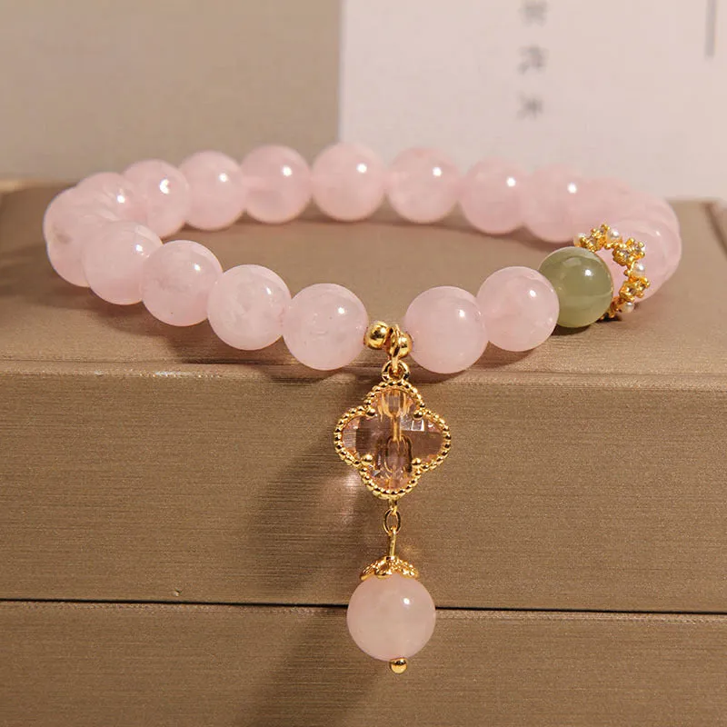Pink crystal women's bracelet with a four-leaf clover pendant and sparkling rhinestone details.