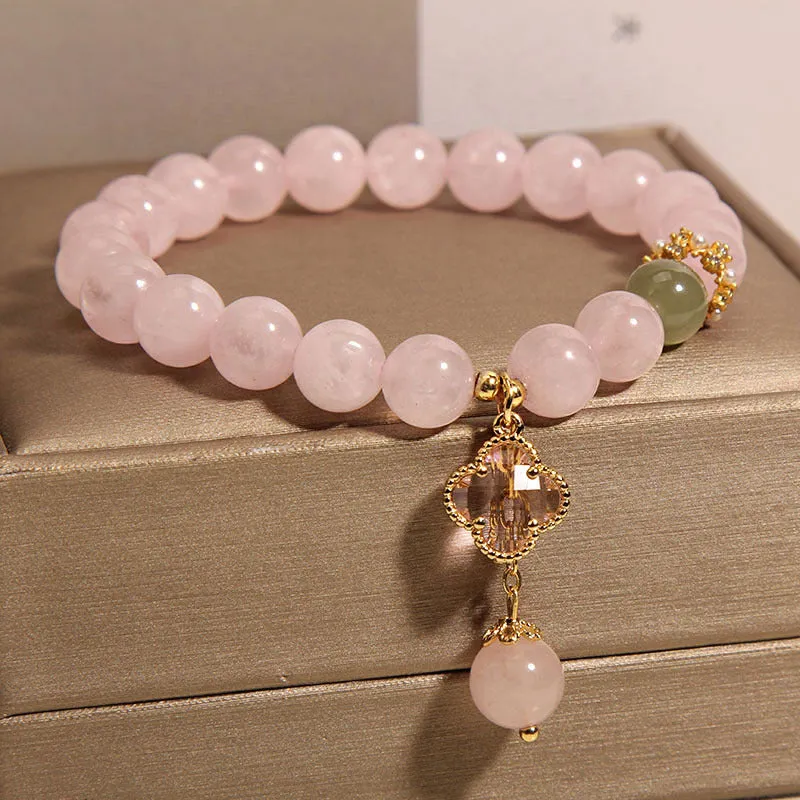 Pink crystal women's bracelet with a four-leaf clover pendant and sparkling rhinestone details.