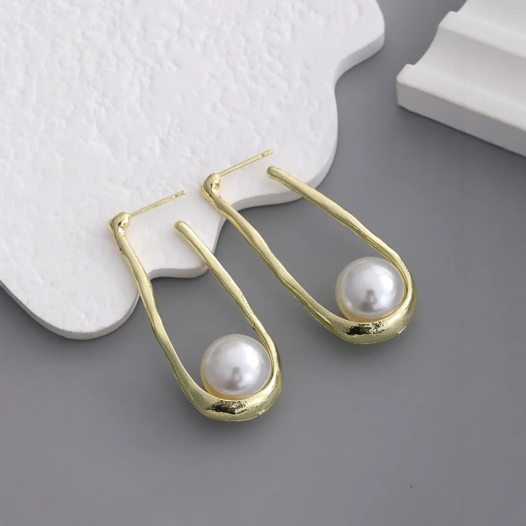 Gold-tone hook earrings with an irregular natural pearl in a vintage European style