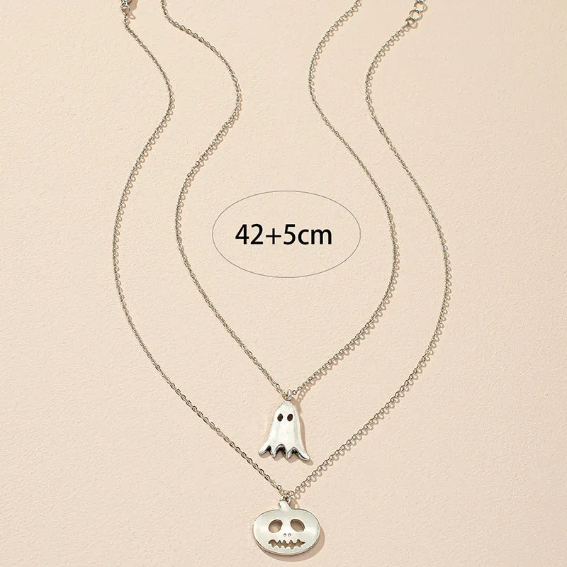 Two silver alloy pendant necklaces: one cartoon pumpkin and one cartoon ghost on a light background