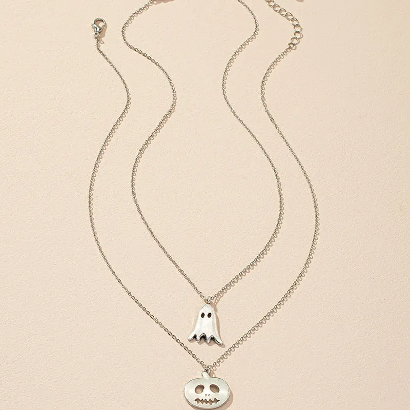 Two silver alloy pendant necklaces: one cartoon pumpkin and one cartoon ghost on a light background