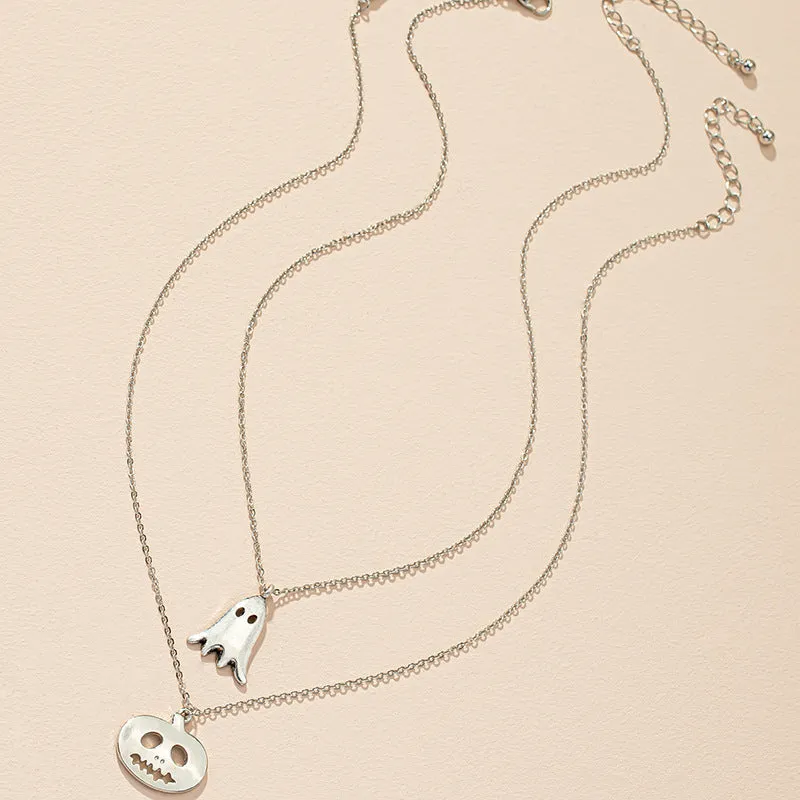 Two silver alloy pendant necklaces: one cartoon pumpkin and one cartoon ghost on a light background