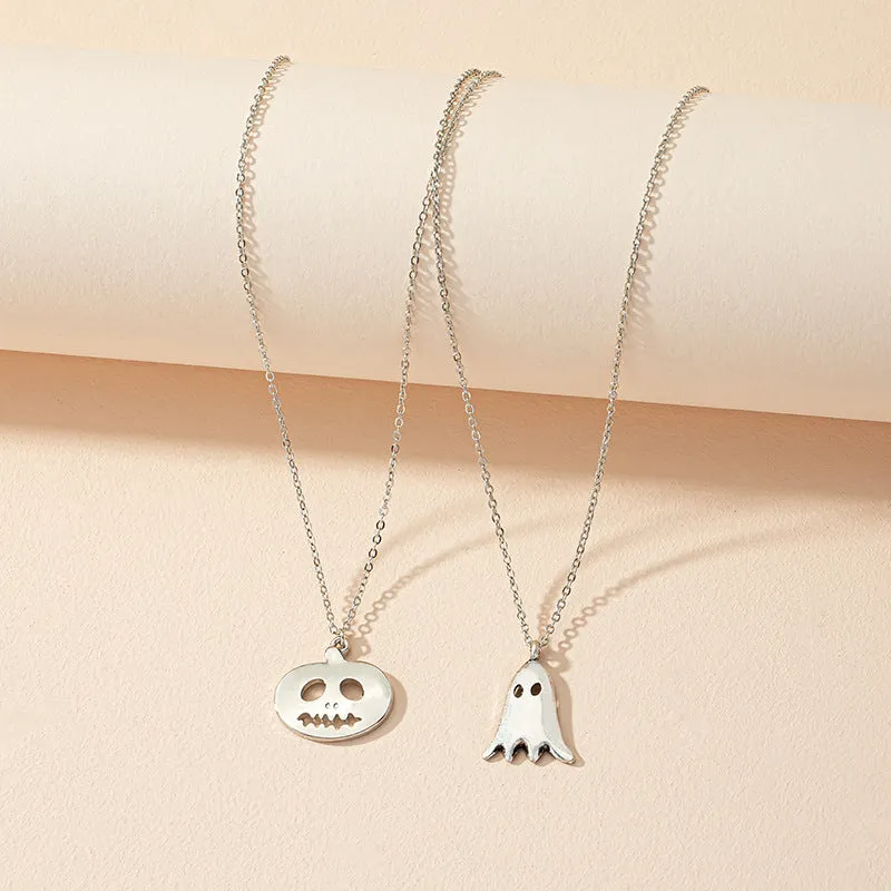 Two silver alloy pendant necklaces: one cartoon pumpkin and one cartoon ghost on a light background