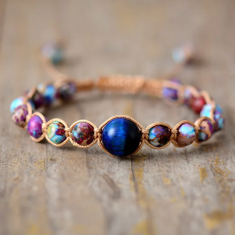 Hand woven friendship bracelet with adjustable cord and single Emperor Stone bead on a plain background.