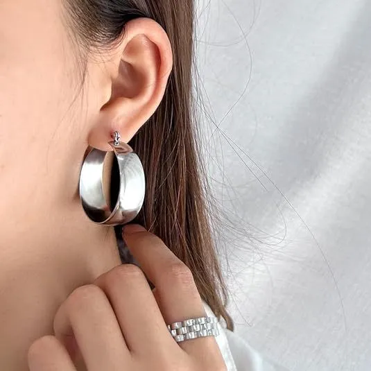 Widened curved stainless steel earrings in gold and steel colours showing 25mm and 30mm size options