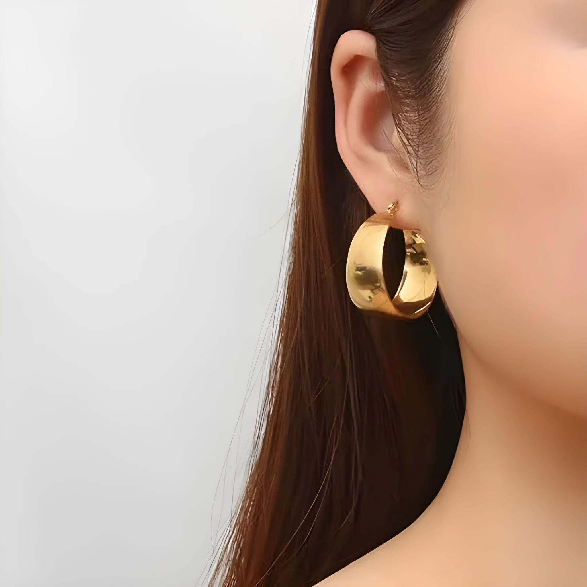 Widened curved stainless steel earrings in gold and steel colours showing 25mm and 30mm size options