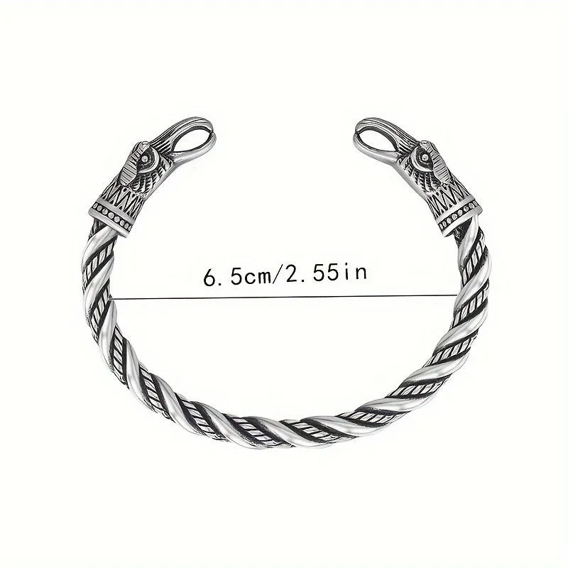 Retro Nordic Viking crow open-ended silver alloy bracelet on a flat surface