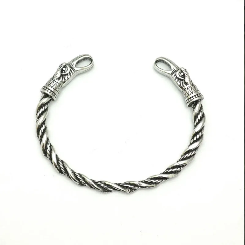 Retro Nordic Viking crow open-ended silver alloy bracelet on a flat surface