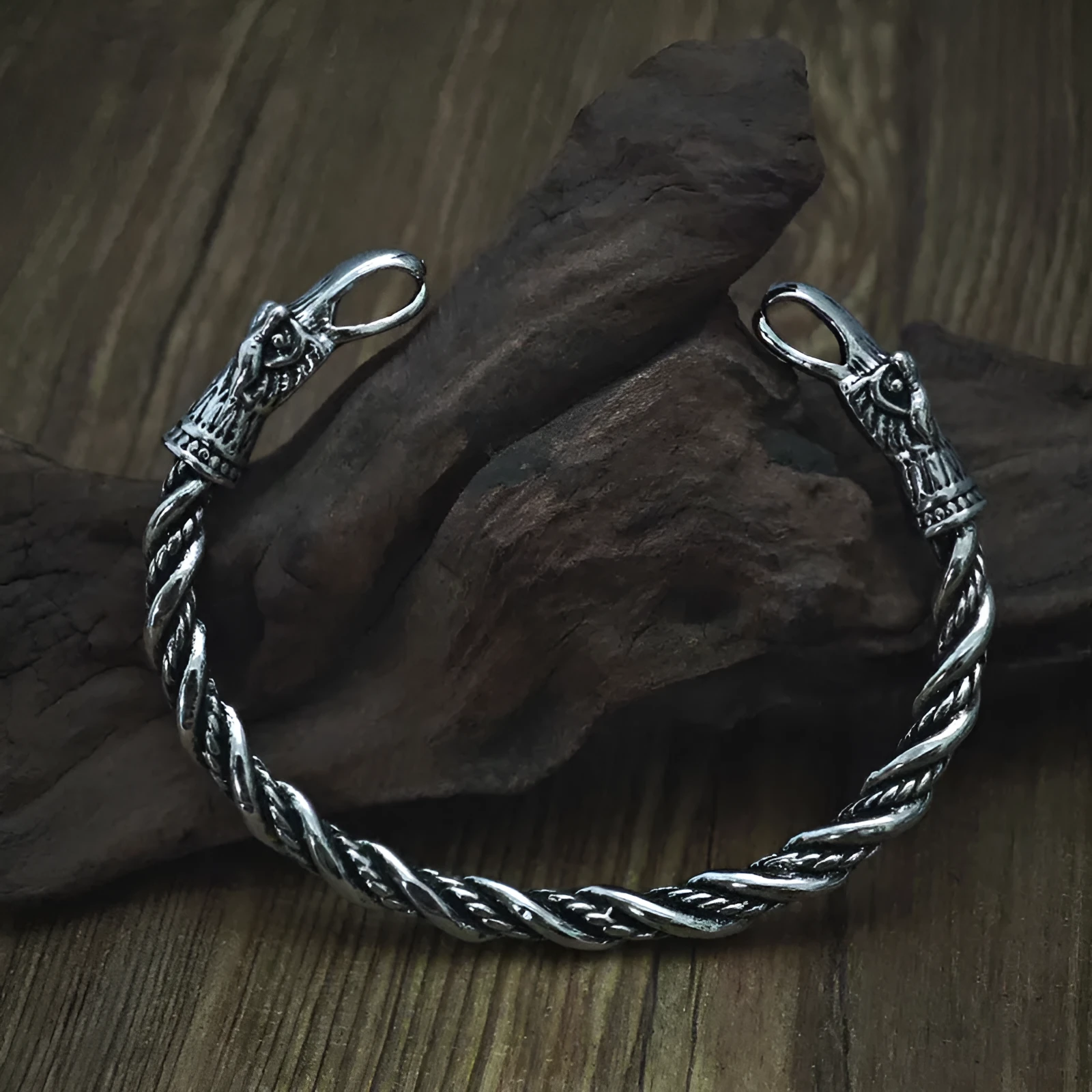 Retro Nordic Viking crow open-ended silver alloy bracelet on a flat surface