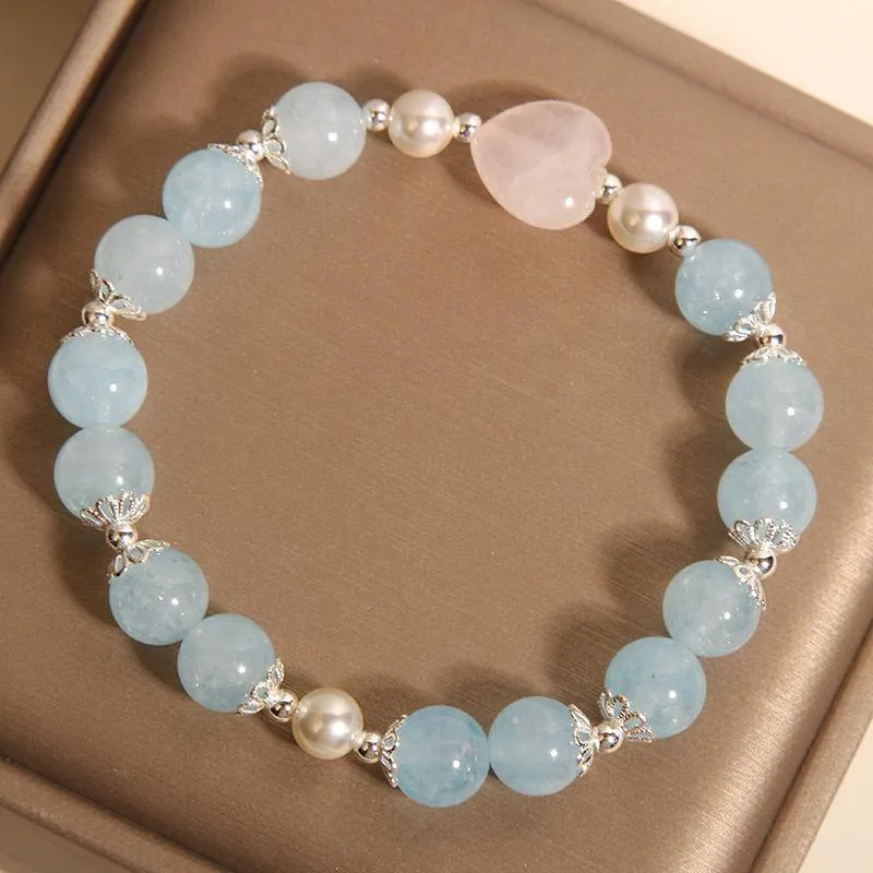 Natural aquamarine crystal bracelet with three shell pearls and lobster clasp on display