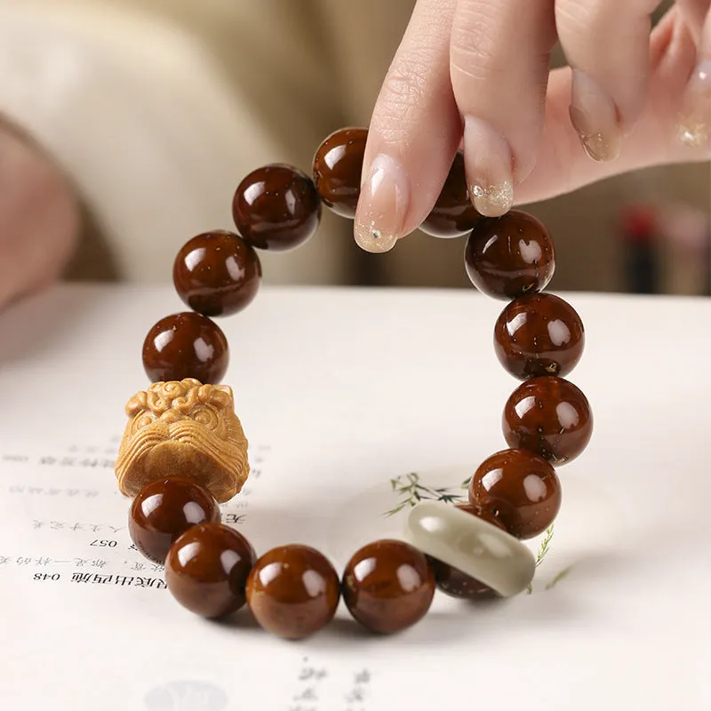 Hand-woven bracelet with 13mm round beads and a carved lion bead centrepiece in ivory nut style.