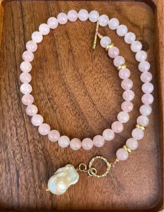 Women's handmade stainless steel pink crystal bracelet and necklace set, modern minimalist 10mm jewellery on a flat surface