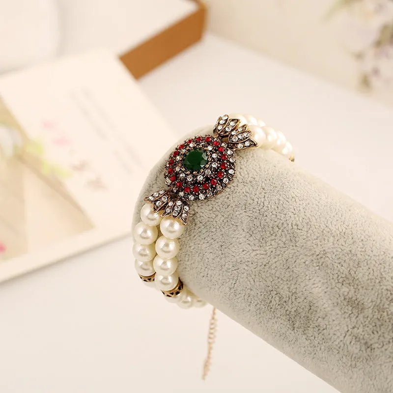 Luxury pearl bracelet in green and red alloy metal on display