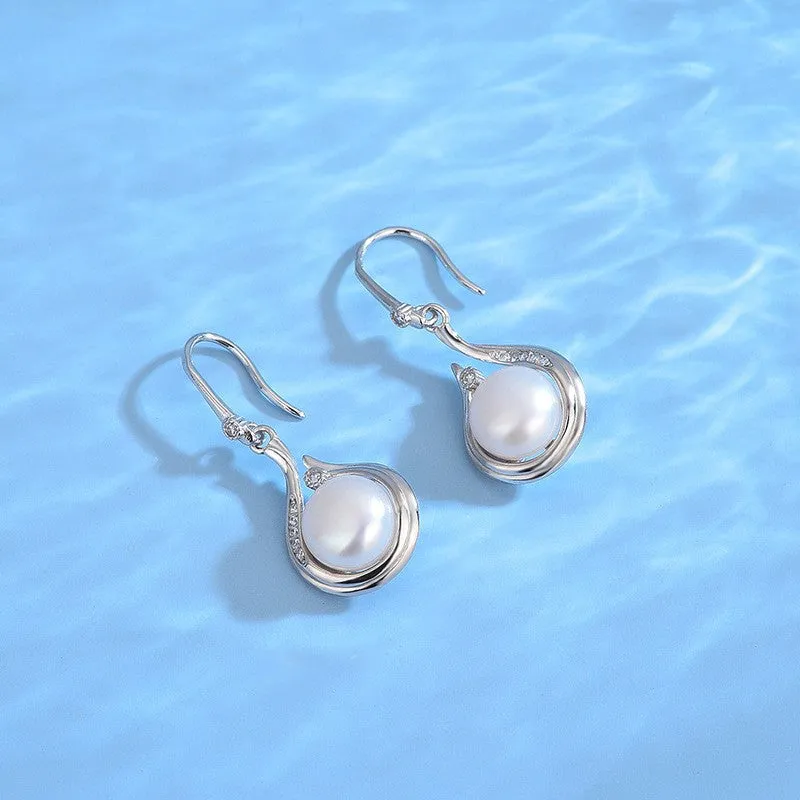 S925 silver necklace with natural freshwater pearl and geometric mother-of-pearl pendant on cross chain over a knitted sweater