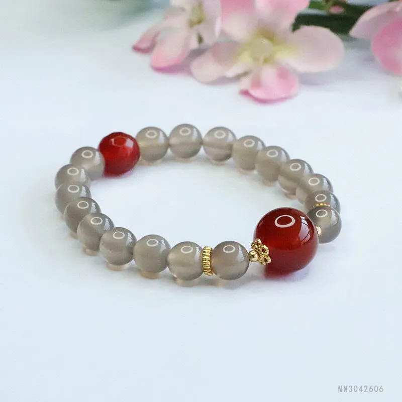 Smoky purple and red agate bracelet with 8mm geometric beads on a white background.