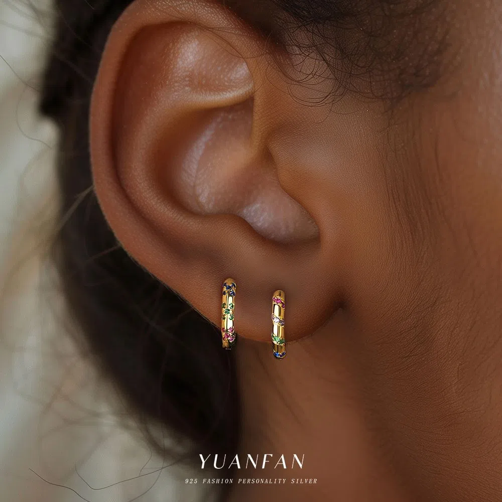 S925 sterling silver geometric earrings with yellow gold finish and inlaid zircon stone on white background