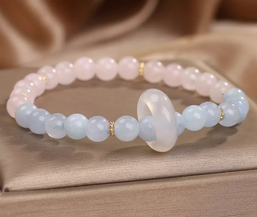 Natural aquamarine crystal beaded bracelet with pink electroplated finish on display