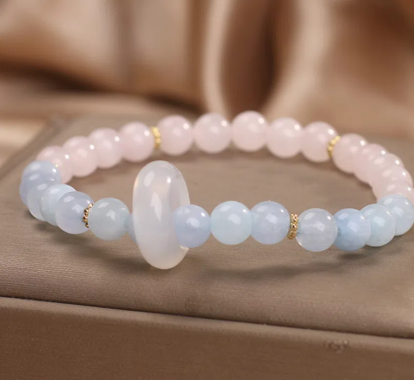 Natural aquamarine crystal beaded bracelet with pink electroplated finish on display