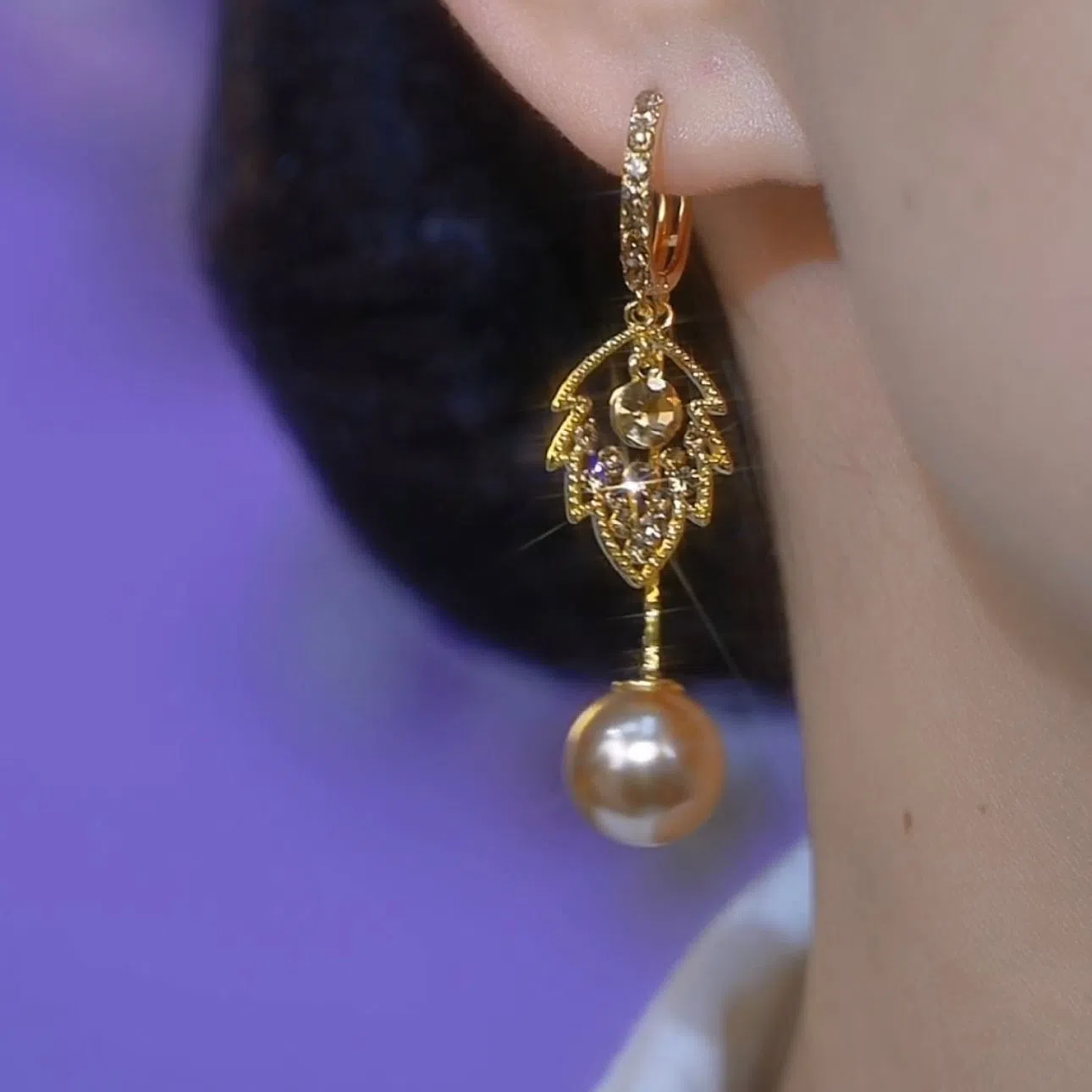 Coffee-coloured metal leaf earrings with full diamond-cut surface and pearl accents, old money style, side view on white background
