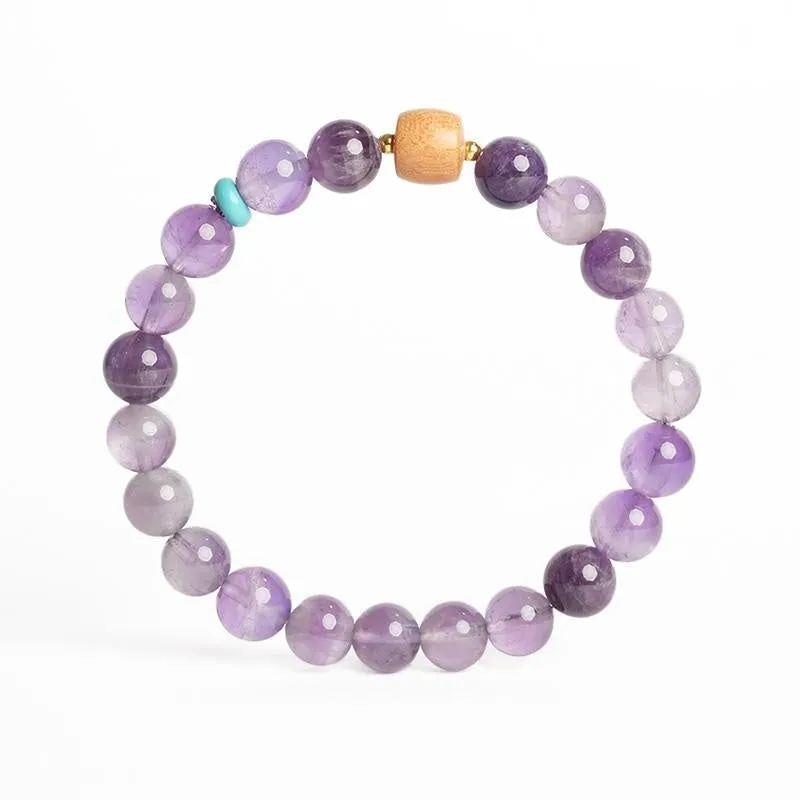 Handmade purple amethyst crystal bracelet for women on a wrist.