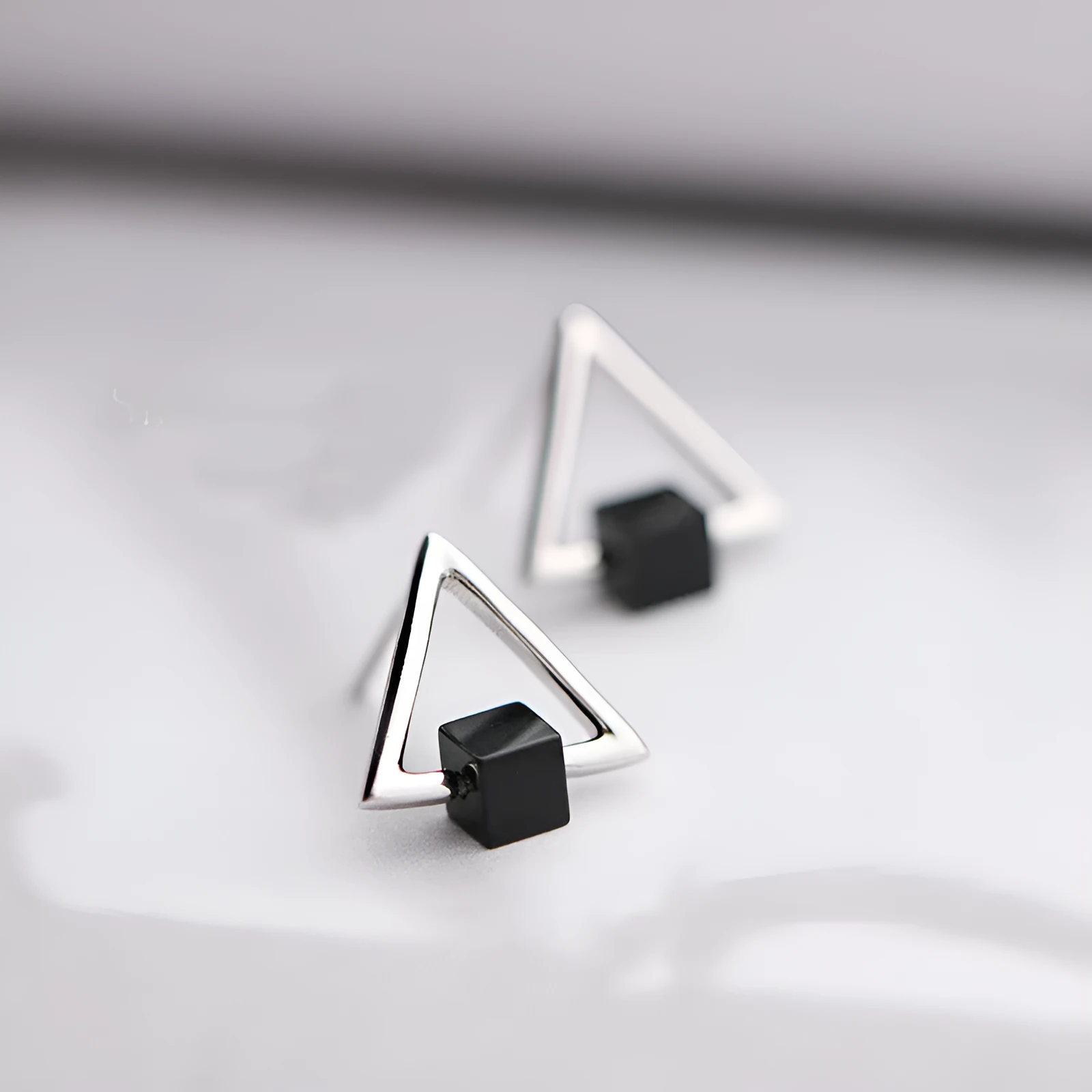 Sterling silver S925 geometric triangle black earrings with gem inlay on neutral background