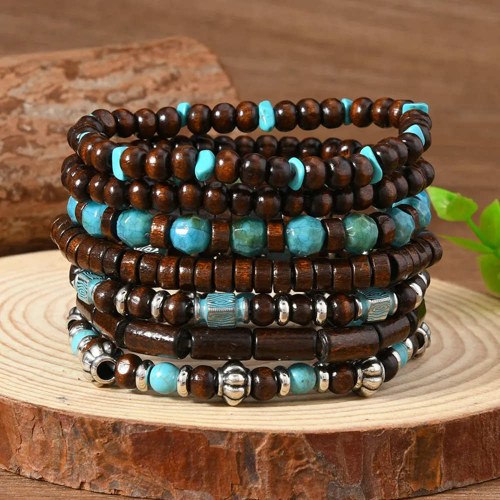 Set of seven multicolour retro bracelets with wooden beads and alloy accents laid flat.