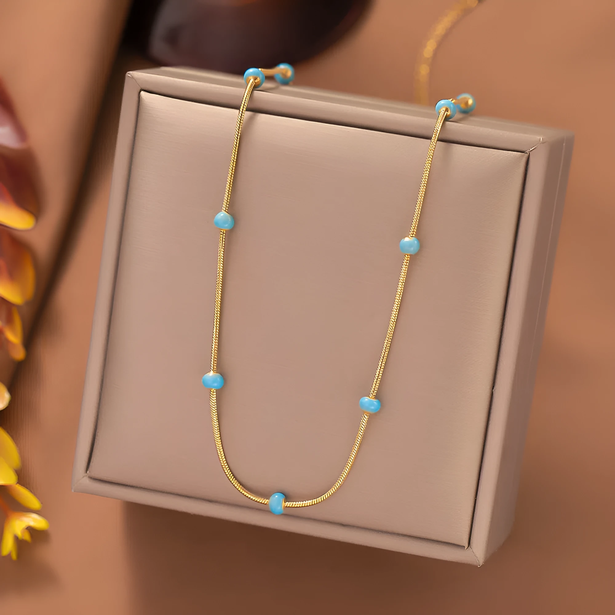Titanium steel ball drop glaze necklace in green pearl gold, clavicle length, on model