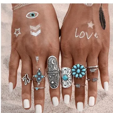 Boho vintage ring set in ancient silver with flower engraving and gemstone inlay laid out on a flat surface