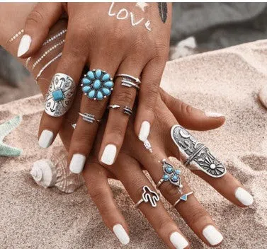 Boho vintage ring set in ancient silver with flower engraving and gemstone inlay laid out on a flat surface