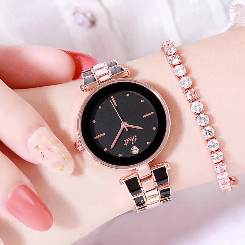 White dial ladies quartz watch with rose gold accents, steel strap, 30mm round alloy case on flat surface