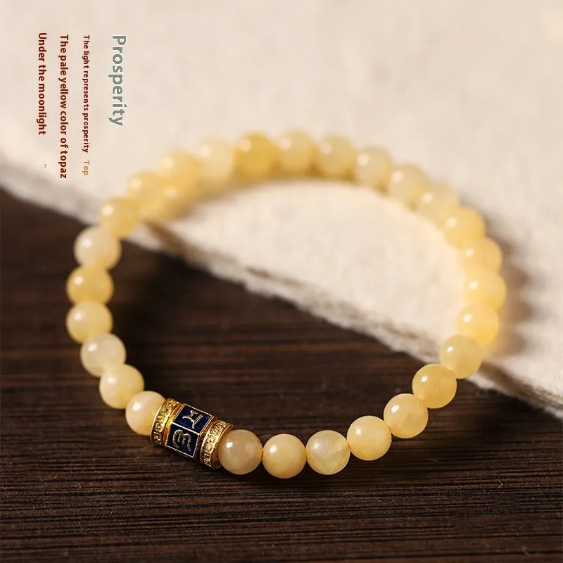 Women's hand-woven topaz bracelet with mantra barrel beads, square sugar beads, and fu charm in yellow jade