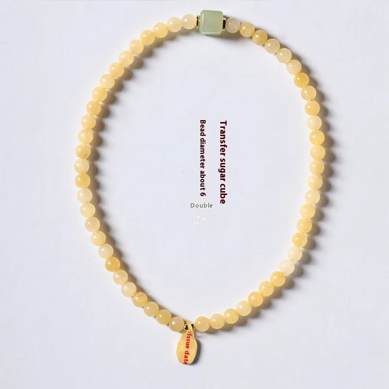Women's hand-woven topaz bracelet with mantra barrel beads, square sugar beads, and fu charm in yellow jade