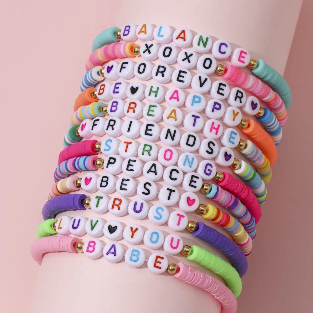 Children's polymer clay bracelet with dinosaur bead theme on a white background