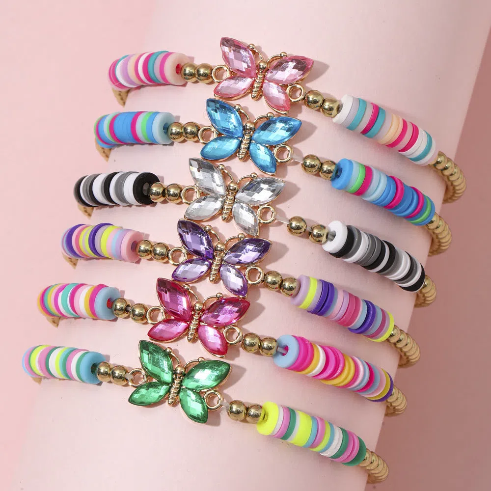 Children's polymer clay bracelet with dinosaur bead theme on a white background