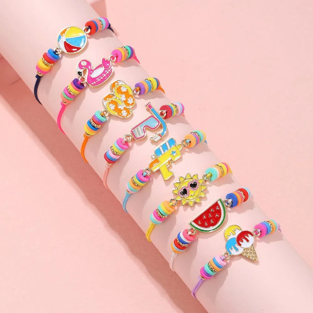 Children's polymer clay bracelet with dinosaur bead theme on a white background