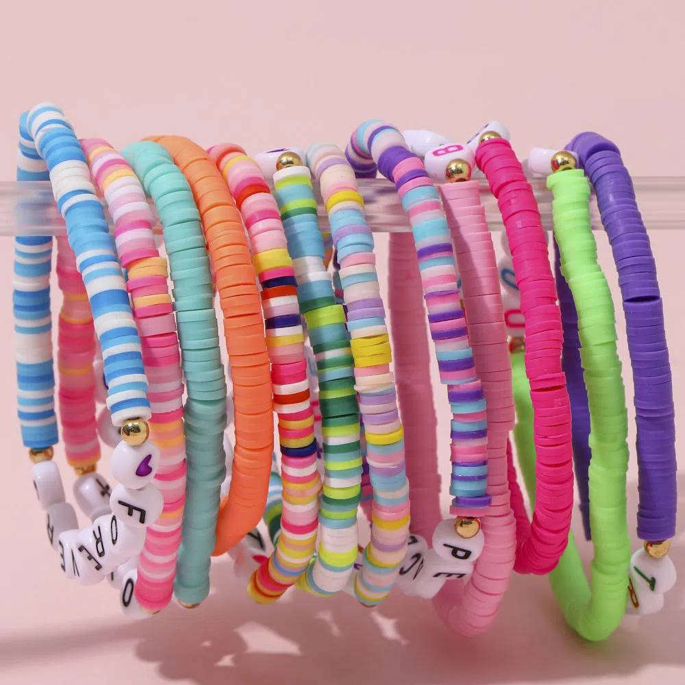 Children's polymer clay bracelet with dinosaur bead theme on a white background