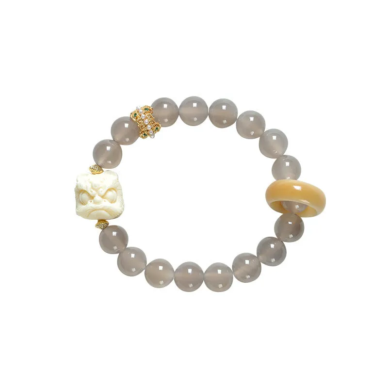 Hand-woven bracelet with large round grey agate and mellite beads on wrist.
