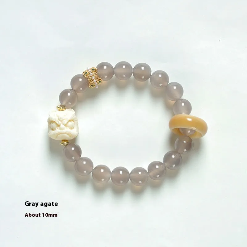 Hand-woven bracelet with large round grey agate and mellite beads on wrist.