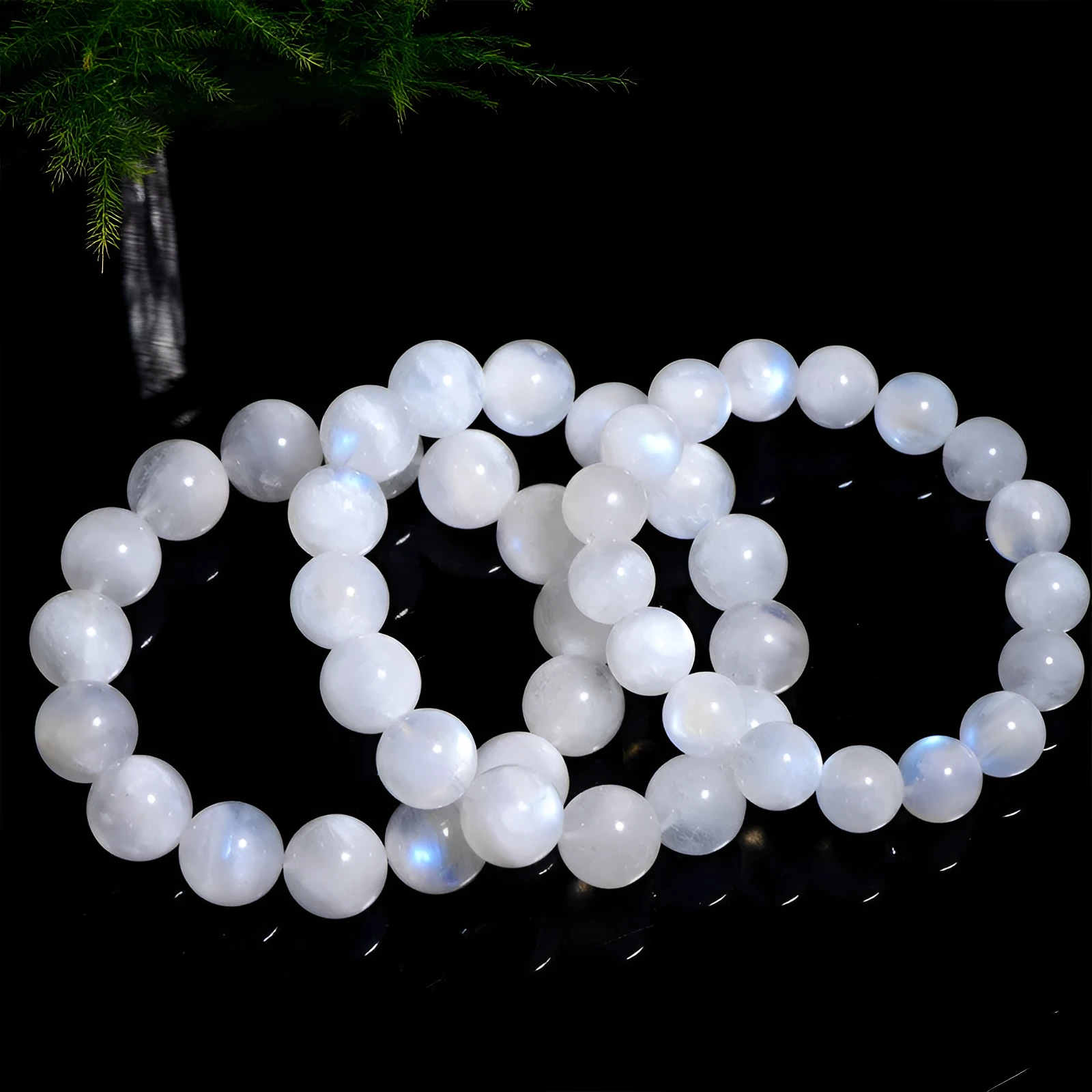 Natural white Moonstone round bead bracelet on a wrist, showing polished geometry beads.