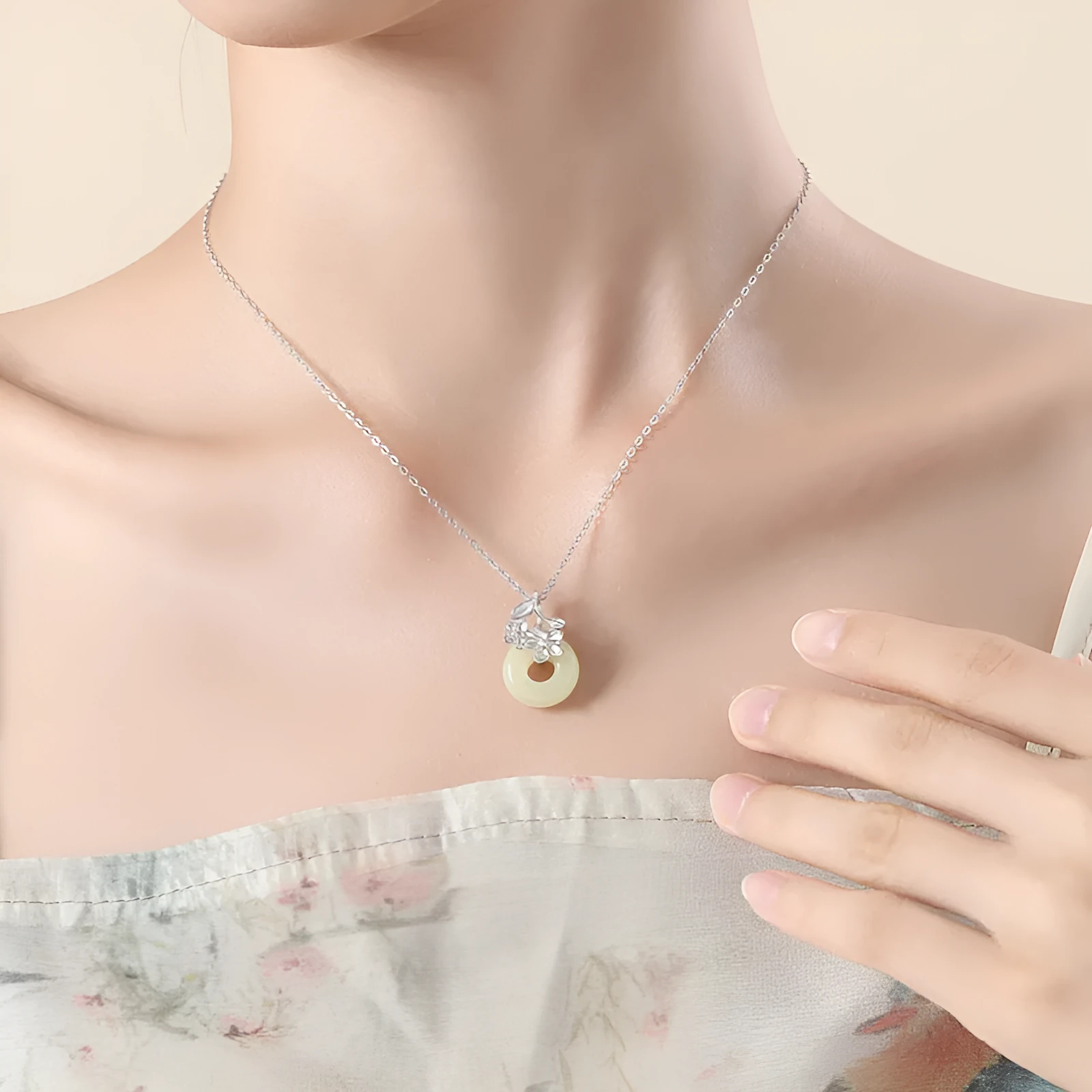 Silver pendant necklace with a peace buckle design on an adjustable cross chain.