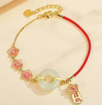 Peach blossom Hetian jade bracelet and necklace set with flower-shaped beads in sterling silver setting