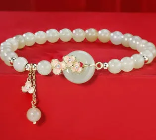 Peach blossom Hetian jade bracelet and necklace set with flower-shaped beads in sterling silver setting