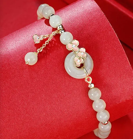 Peach blossom Hetian jade bracelet and necklace set with flower-shaped beads in sterling silver setting
